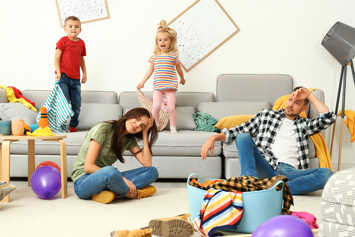 Man and woman sitting on floor surrounded by children's toys